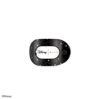 Black Disney-themed flat round hair clip with Mickey Mouse pattern and Disney TELETIES branding.