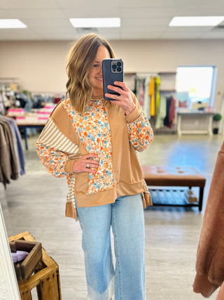 Woman wearing Haptics Floral & Striped Colorblock Harmony Top with wide-leg jeans in boutique mirror selfie.