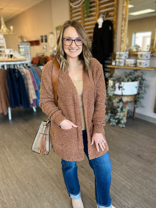 Woman wearing cozy textured mocha cardigan with jeans in retail store setting