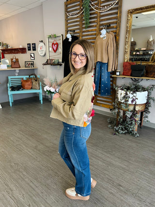 Woman wearing Carol Christian Garden Party Denim Jacket with floral embroidery in boutique setting