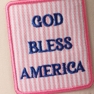 Embroidered "God Bless America" patch with blue lettering on a pink striped woven background.
