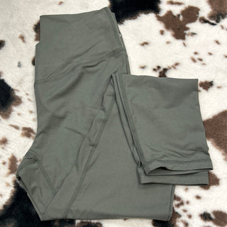 Grey athletic leggings with high waistband and side seam details laid on cowhide rug
