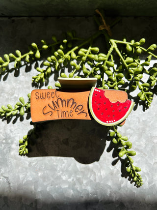 Handmade hair clips with "Sweet Summer Time" text and watermelon design on succulent plant background.