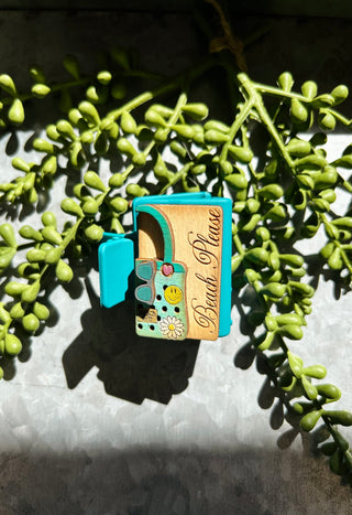 Handmade small hair clips with decorative patches displayed on succulent plant branch in natural sunlight.