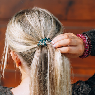 TELETIES Harvest Hues Large Hair Ties securing a blonde ponytail, shown with spiral bracelet on wrist.