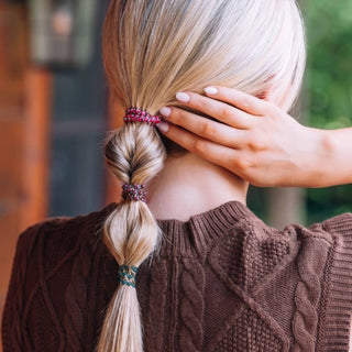 Blonde woman wearing TELETIES spiral hair ties in a sectioned ponytail, viewed from behind.
