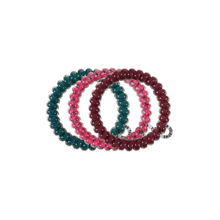 Set of four spiral coil hair ties in autumn-inspired tones, displayed overlapping on black background.
