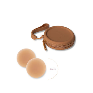 Skin-toned silicone nipple covers with brown zippered carrying case and wrist strap