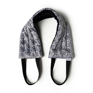 DM Merchandising heated neck wrap with geometric pattern design and black adjustable straps on white background