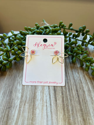 Gold flower-shaped hoop earrings displayed on branded card with succulent plants on wood surface
