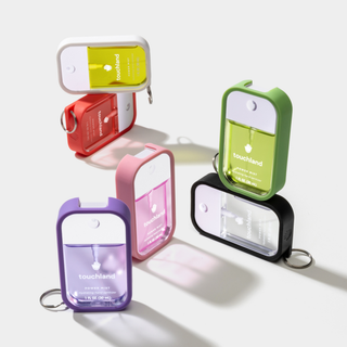 Six Touchland Power Mist hand sanitizer bottles displayed in colorful silicone cases with keyring attachments.