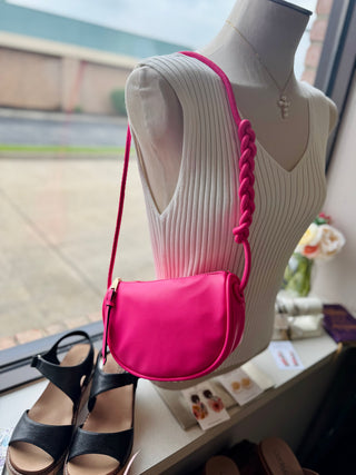 Knotted strap crossbody bag displayed on dress form mannequin with coordinating sandals nearby