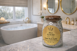 All Good Home & Body Calm Bath Salts jar with cork lid on marble bathroom countertop.