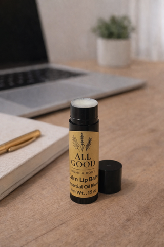 All Good Home & Body Calm Lip Balm open tube displayed on wooden desk with laptop background.