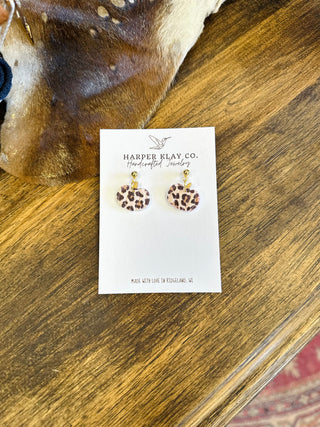 Leopard print pumpkin earrings on Harper Klay Co. jewelry card displayed on wooden surface.