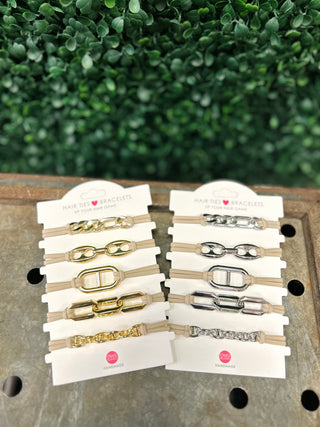 Two sets of chain-link hair tie bracelets in gold and silver tones displayed on packaging cards.