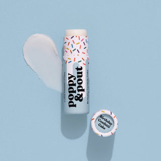Poppy & Pout lip balm tube with colorful sprinkle design and white product swatch on blue background