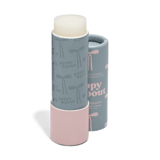 Poppy & Pout French Macaron lip balm tube with decorative bow-patterned packaging sleeve