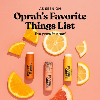 Poppy & Pout lip balm tubes surrounded by orange and lemon slices on coral background with Oprah endorsement text