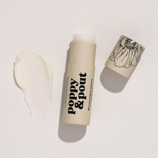 Poppy & Pout lip balm tube with cap removed showing white balm and decorative packaging sleeve