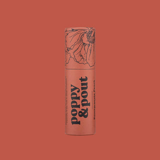 Poppy & Pout lip balm tube with floral design on coral background
