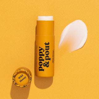 Poppy & Pout Wild Honey lip balm stick with product sample and cap on yellow background.