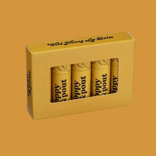 Poppy & Pout Wild Honey Lip Balm four-pack in yellow gift box packaging