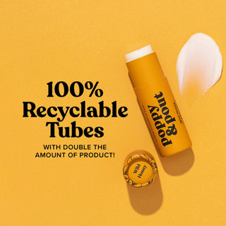 Poppy & Pout Wild Honey lip balm in recyclable orange tube with product scattered on yellow background