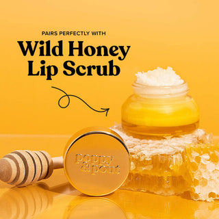 Poppy & Pout Wild Honey Lip Balm with honey dipper, honeycomb, and jar on golden background.