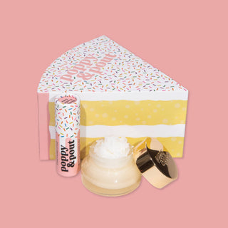 Lip care duo set with lip balm, lip scrub, and decorative envelope on pink background