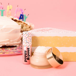 Birthday-themed lip care products displayed with confetti cake and festive decorations on pink background.