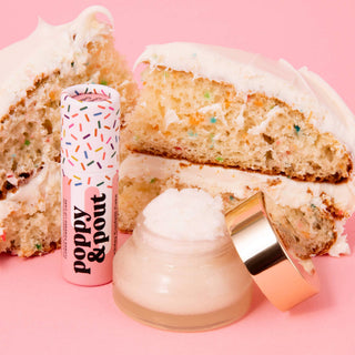 Poppy & Pout lip balm and lip scrub with birthday confetti cake against pink background