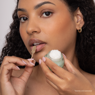 Woman applying Poppy & Pout Sweet Mint lip care products with tool and balm container.