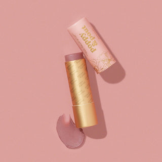 Poppy & Pout Beverly lip tint tube with pink packaging on pink background with shadow