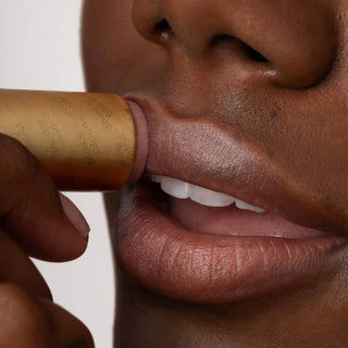 Person applying Poppy & Pout Beverly lip tint with natural finish on full lips.