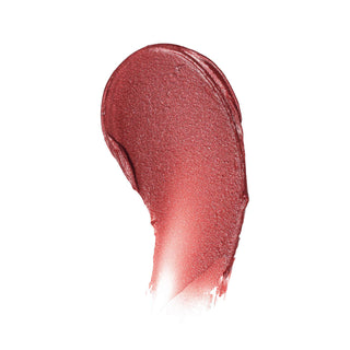 Creamy lip tint swatch with shimmery reddish-pink finish on white background