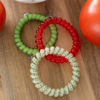 TELETIES hair ties in various colors and patterns displayed on wooden surface with tomatoes
