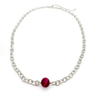 Silver chain necklace with single red gemstone bead centerpiece on white background