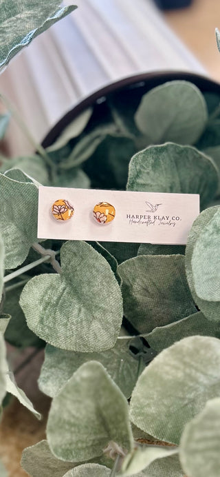 Marigold Garden Stud Earrings by Harper Klay Co displayed on card among green eucalyptus leaves