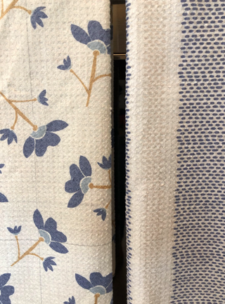 Two kitchen towels with blue floral pattern and blue polka dot pattern on cream background