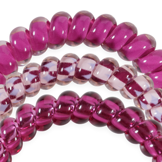 Three strands of glossy glass-look hair ties in solid, striped, and transparent styles arranged in arches.