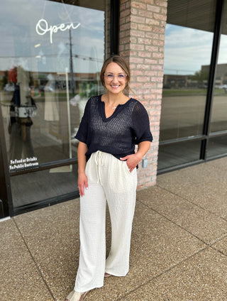 Woman wearing Blu Pepper Midnight Dream Crochet Top with wide-leg pants outside boutique.