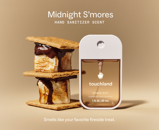 Touchland Power Mist hand sanitizer beside stacked s'mores with melted chocolate and toasted marshmallow.