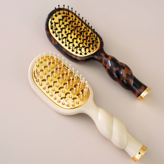Two TELETIES Mini Vented Brushes with gold bases, twisted handles, and ball-tipped bristles on neutral background.