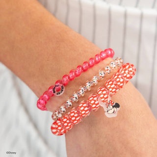 Person wearing three TELETIES hair ties on wrist featuring Minnie Mouse designs and red polka dot patterns.
