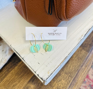 Mint green pumpkin hoop earrings with gold leaf charms displayed on Harper Klay Co. jewelry card.