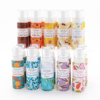 Collection of Mixologie Luxe Room Spray bottles in various colorful scents and decorative packaging designs.