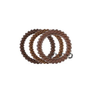 Four TELETIES spiral coil hair ties in warm brown tones, stacked together on a white background.