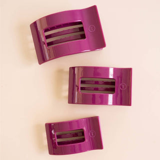 Three glossy rectangular hair clips with open slot design, arranged on a neutral background.