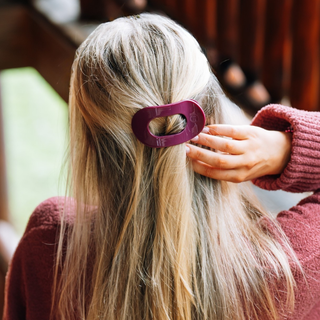 Person wearing a TELETIES flat round hair clip in a half-up hairstyle, viewed from behind.